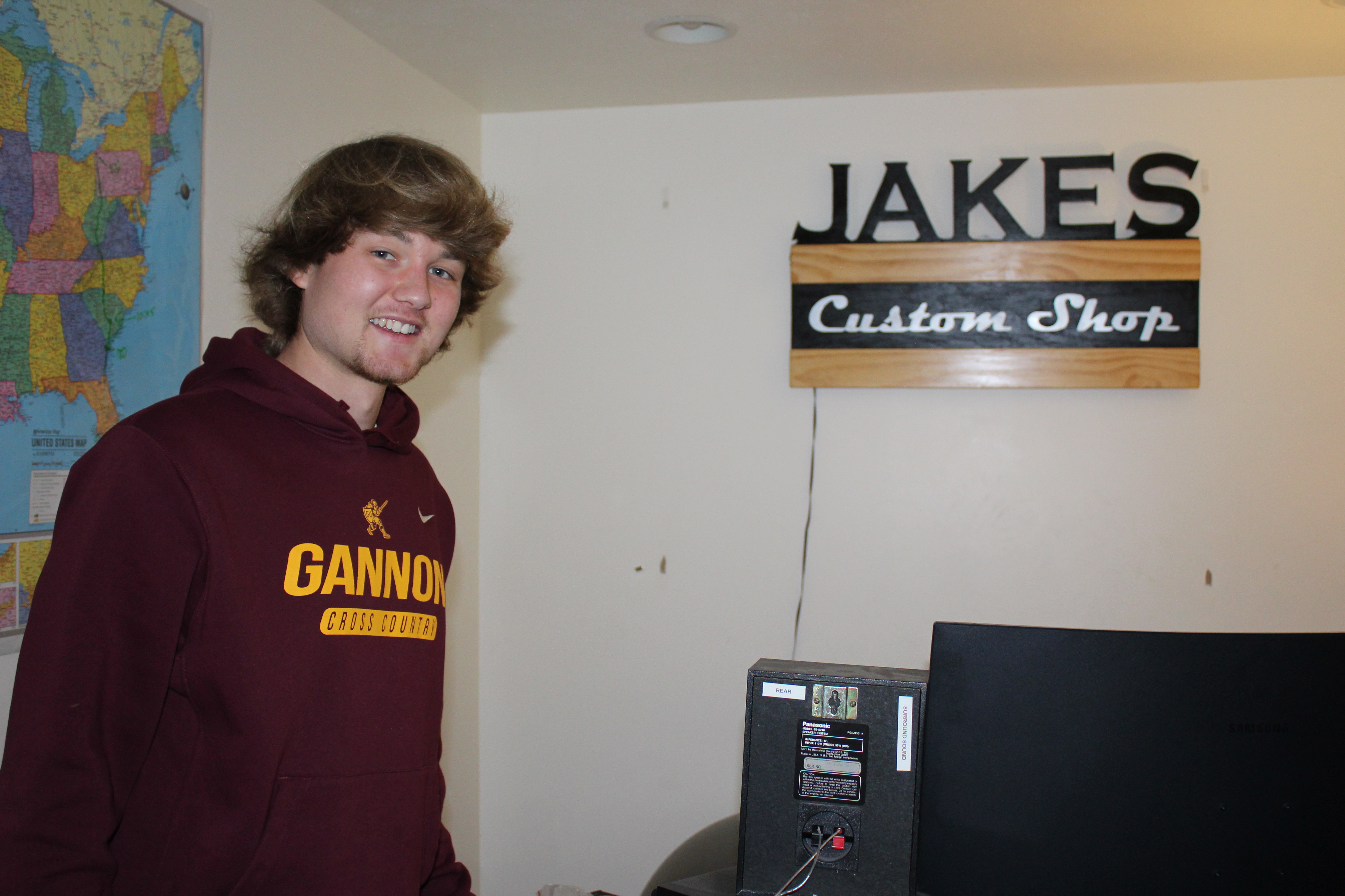 Jake with Jake's Custom Shop sign